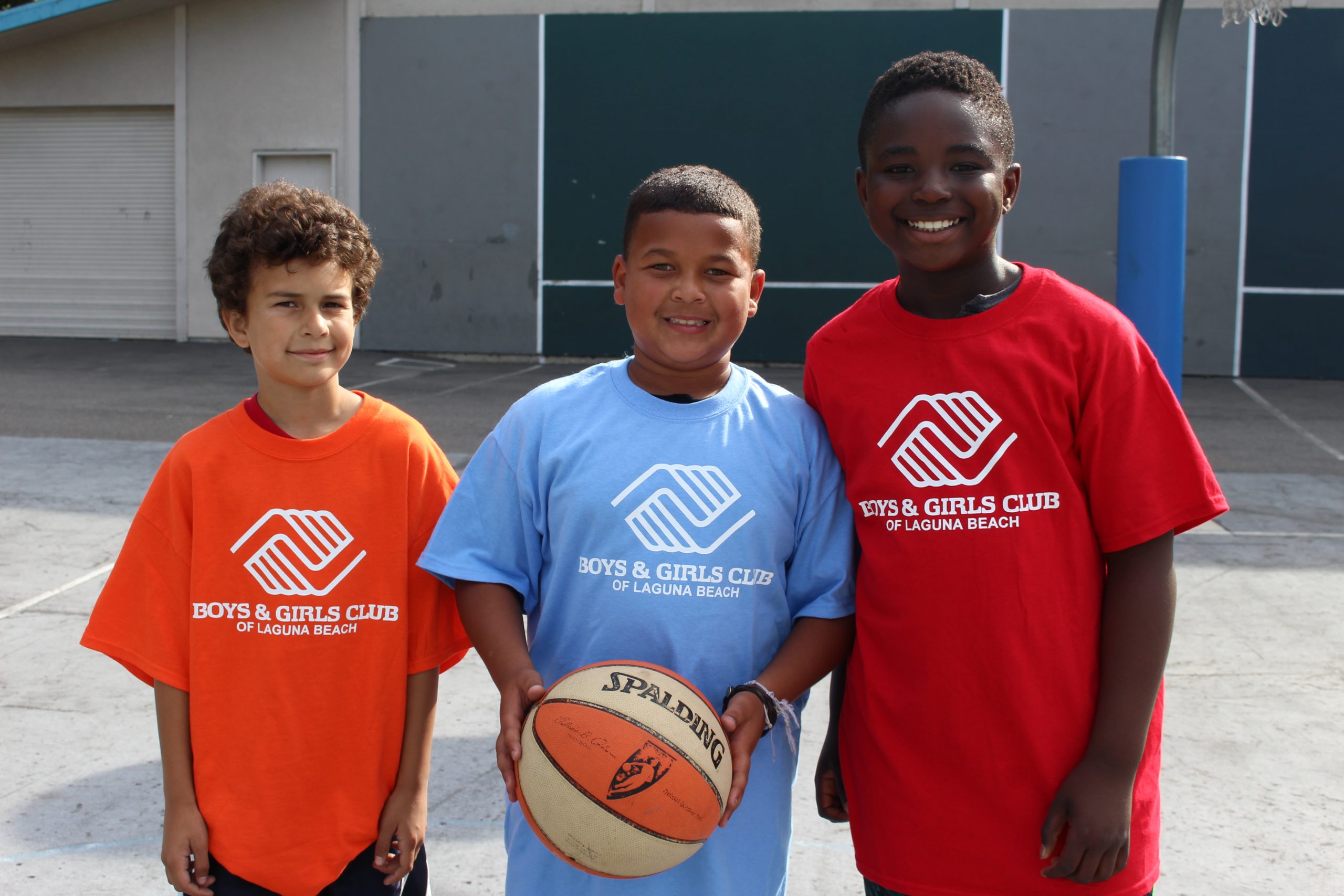 3 boys posing with basketball on playground court at Canyon Enrichment Center