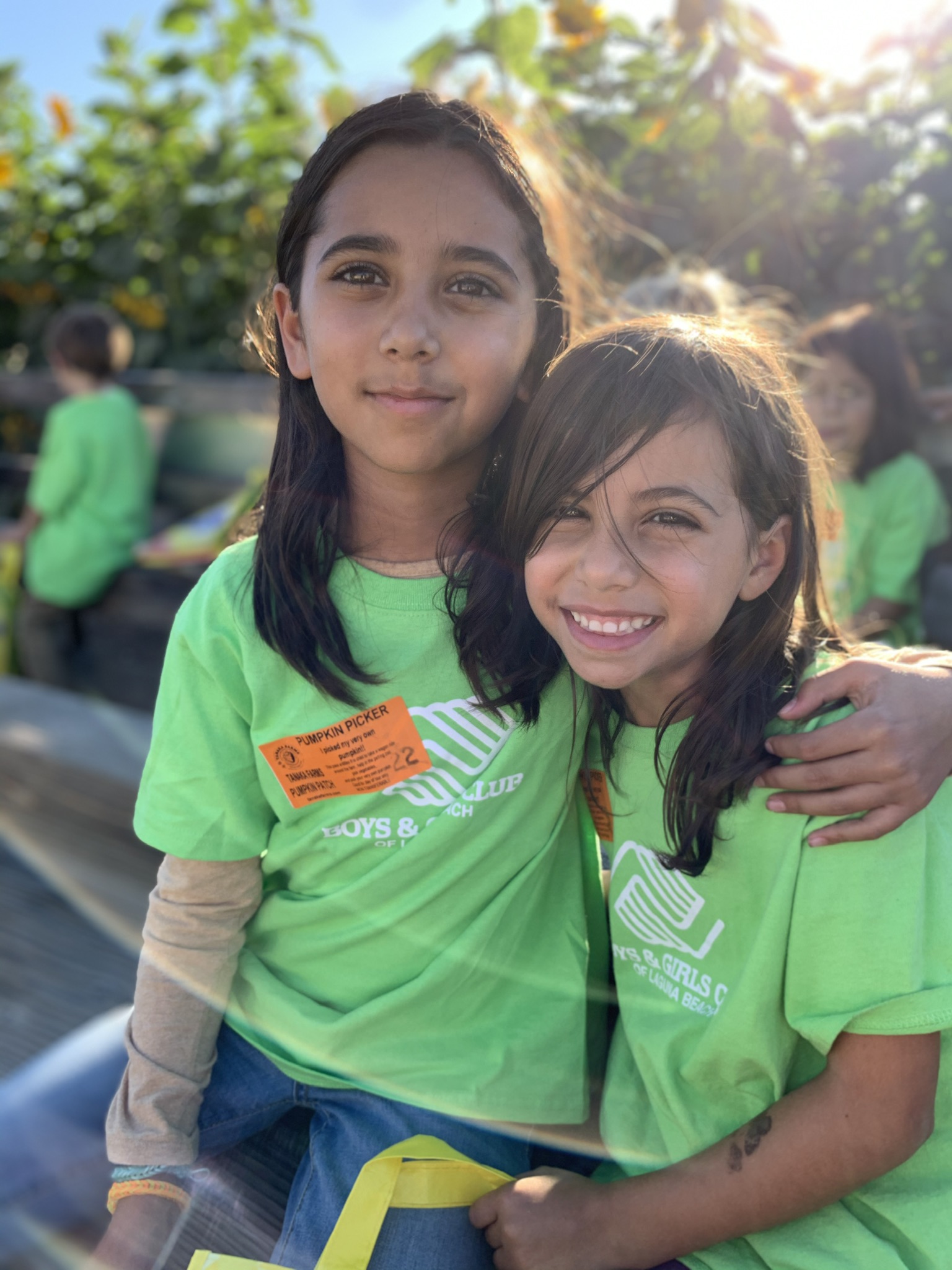 2 sisters sitting on bench at Pumpkin Picker event