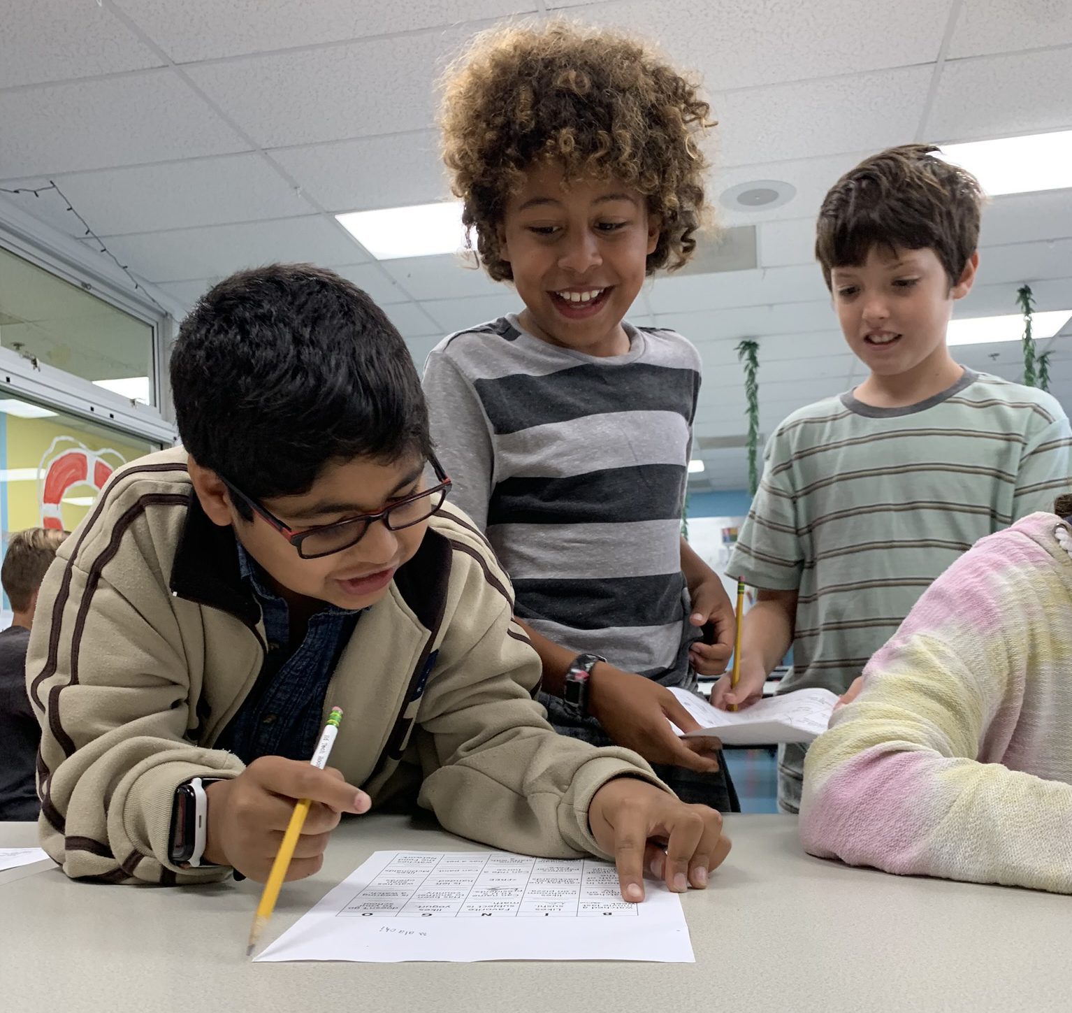 3 boys working on homework together at table