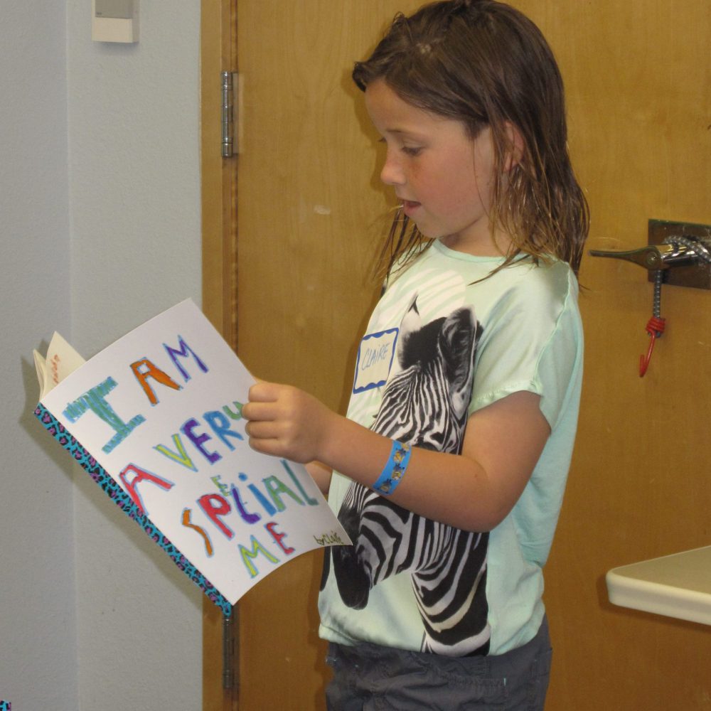young girl reading her self made "I Am A Very Special Me" book