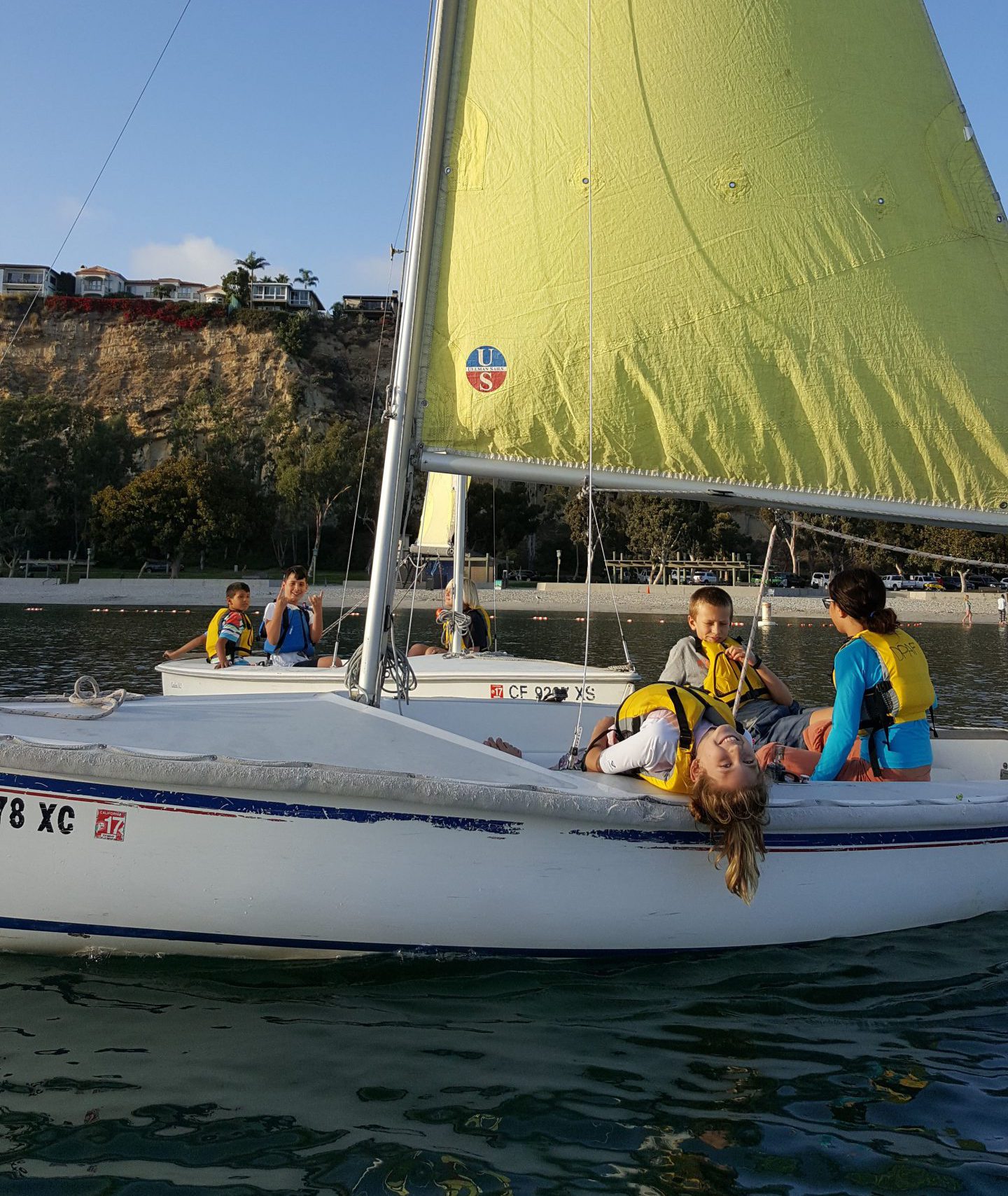 Group of teens sailing in 2 boats at Dana Point Harbor