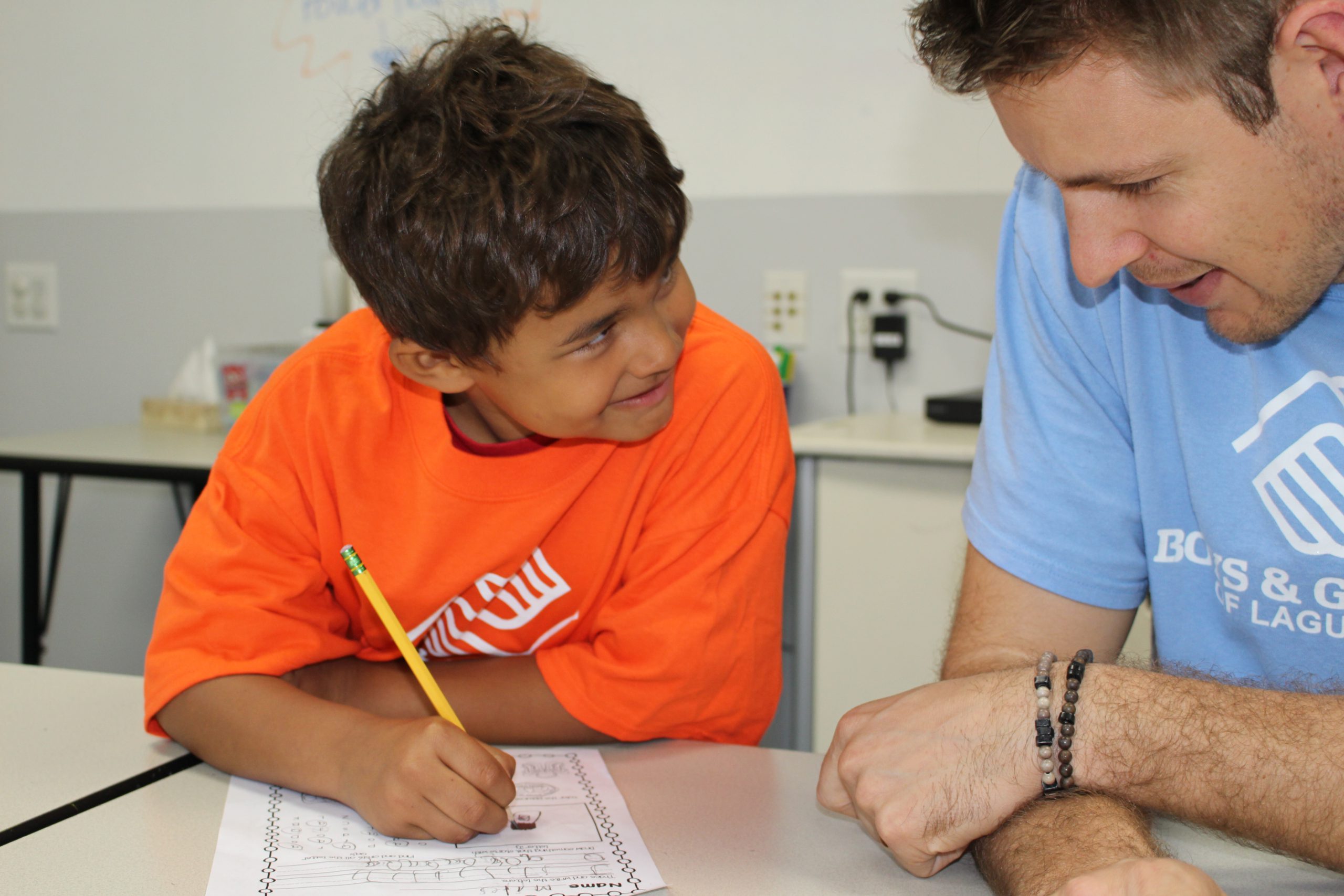 Volunteer helping boy with homework