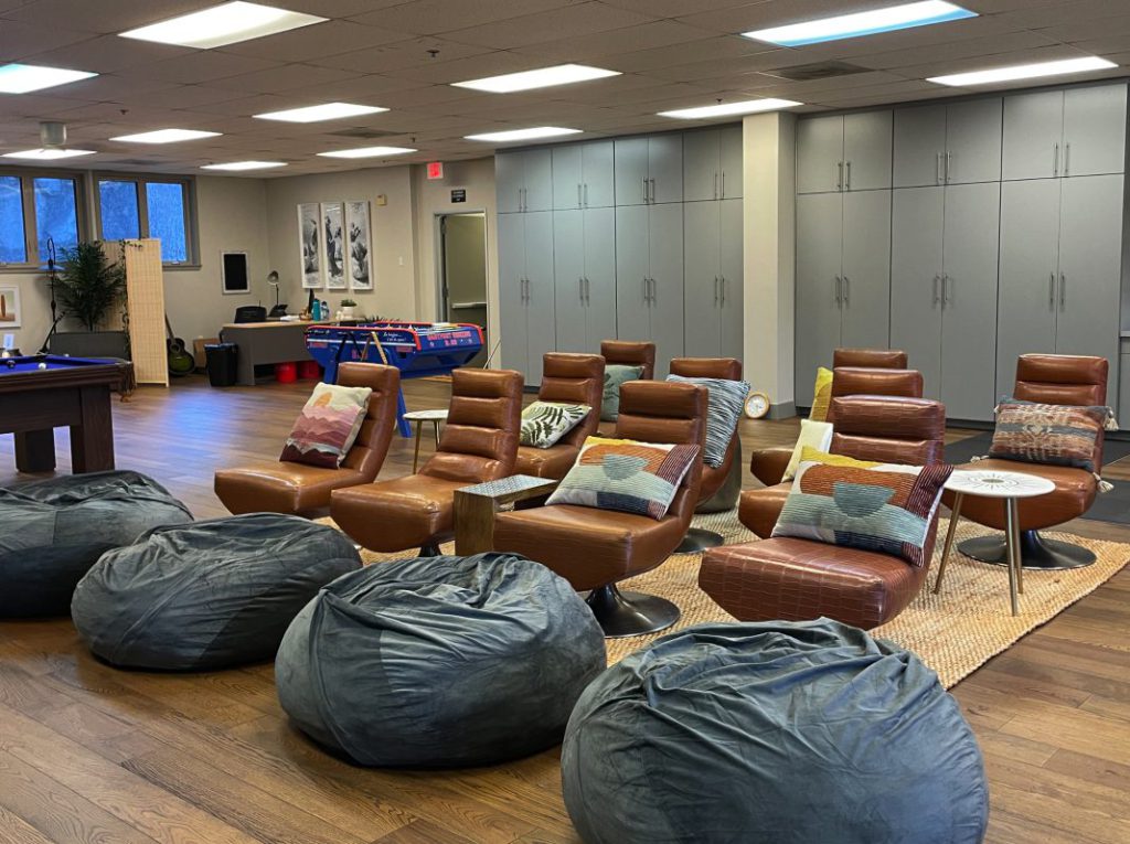 Wide view of the wellness space including lounge chairs, fooseball table, etc.