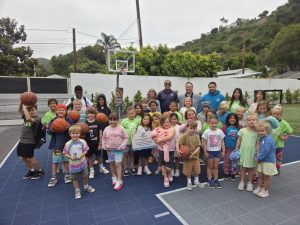 Club members, staff, and Cheng Family Foundation representatives celebrate the dedication of the Boys & Girls Club's restored outdoor basketball court.